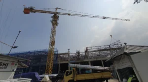 Tower crane berdiri di proyek gedung bertingkat Jakarta dengan pondasi cor atau counterweight