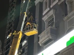 Manlift crane gondola pemasangan neon sign letter box fasad gedung komersial Jakarta